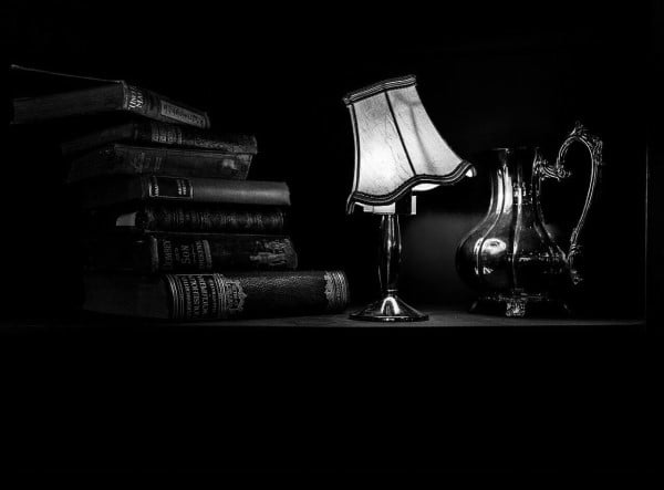Vintage books beside a table lamp
